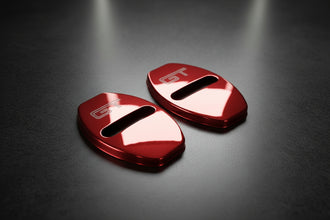 Two red metallic car door handles with 'GT' logo on a white background