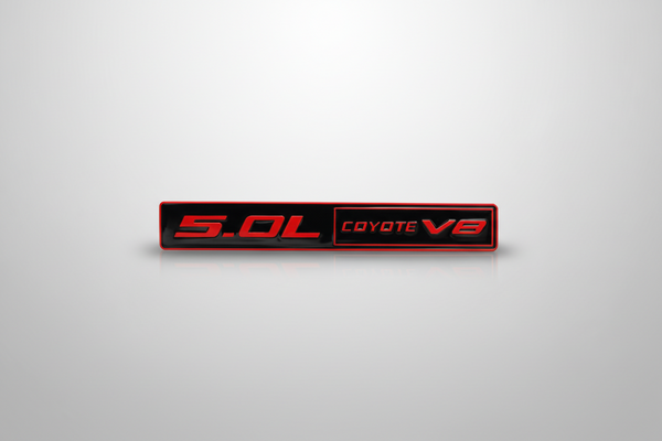 Black and red car emblem with '5.0L COYOTE V8' text on a light gray background
