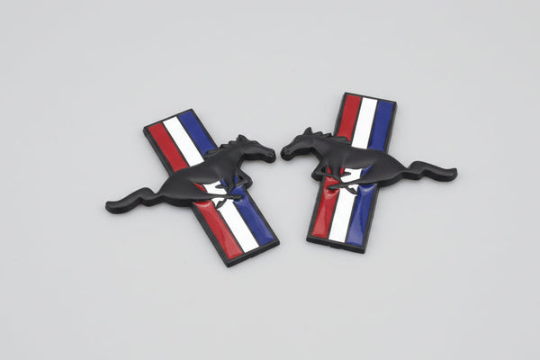 A set of two metal badges with a tri-bar logo against a red, white, and blue striped background.
