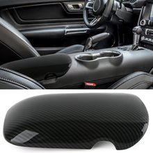 Car interior with a close-up of a carbon fiber-patterned car console cover.