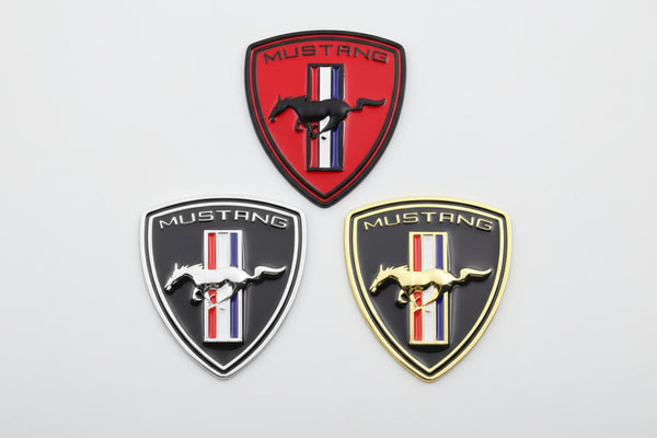 A set of three Mustang Tri-bar Shield Badges in red, black, and gold colors with a white background.